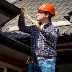 man measuring his roof 